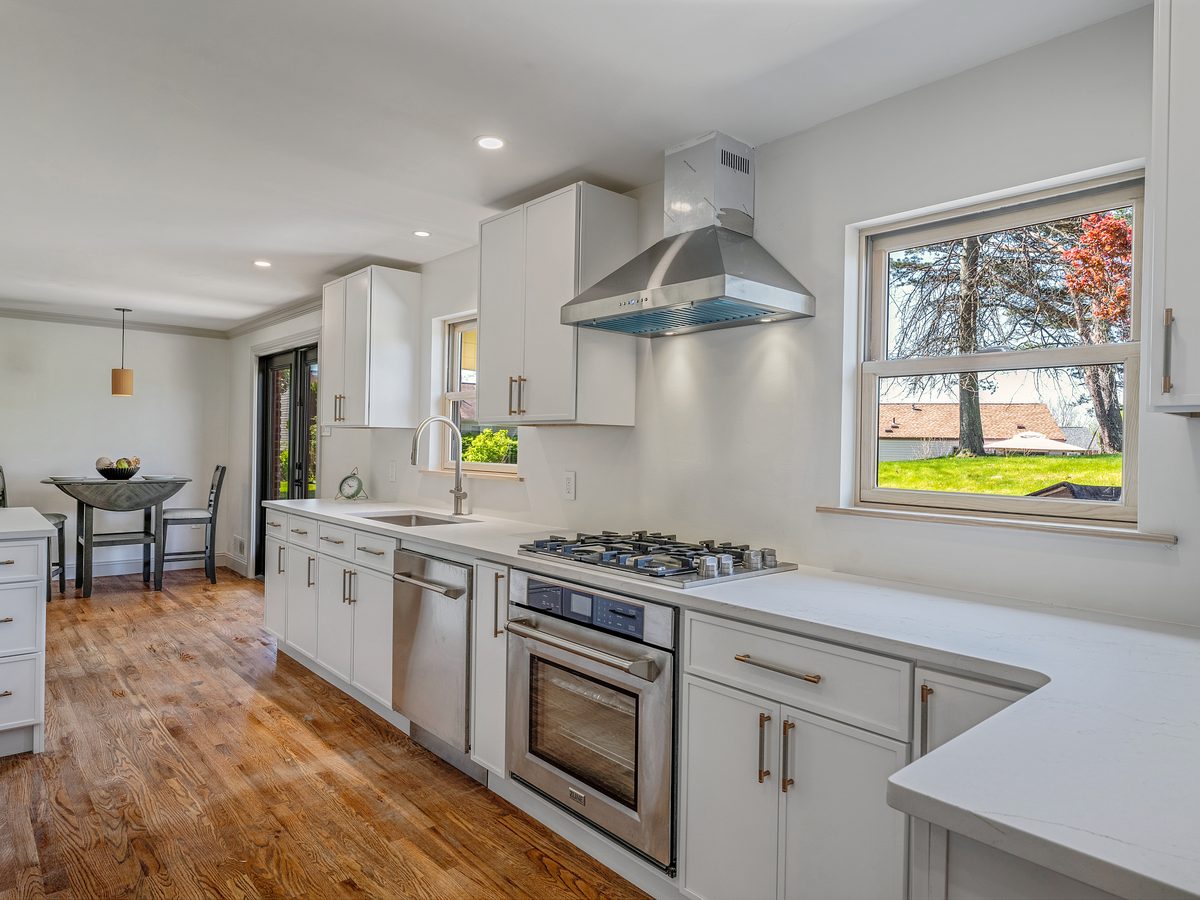 Finished white kitchen with stainless range and hood