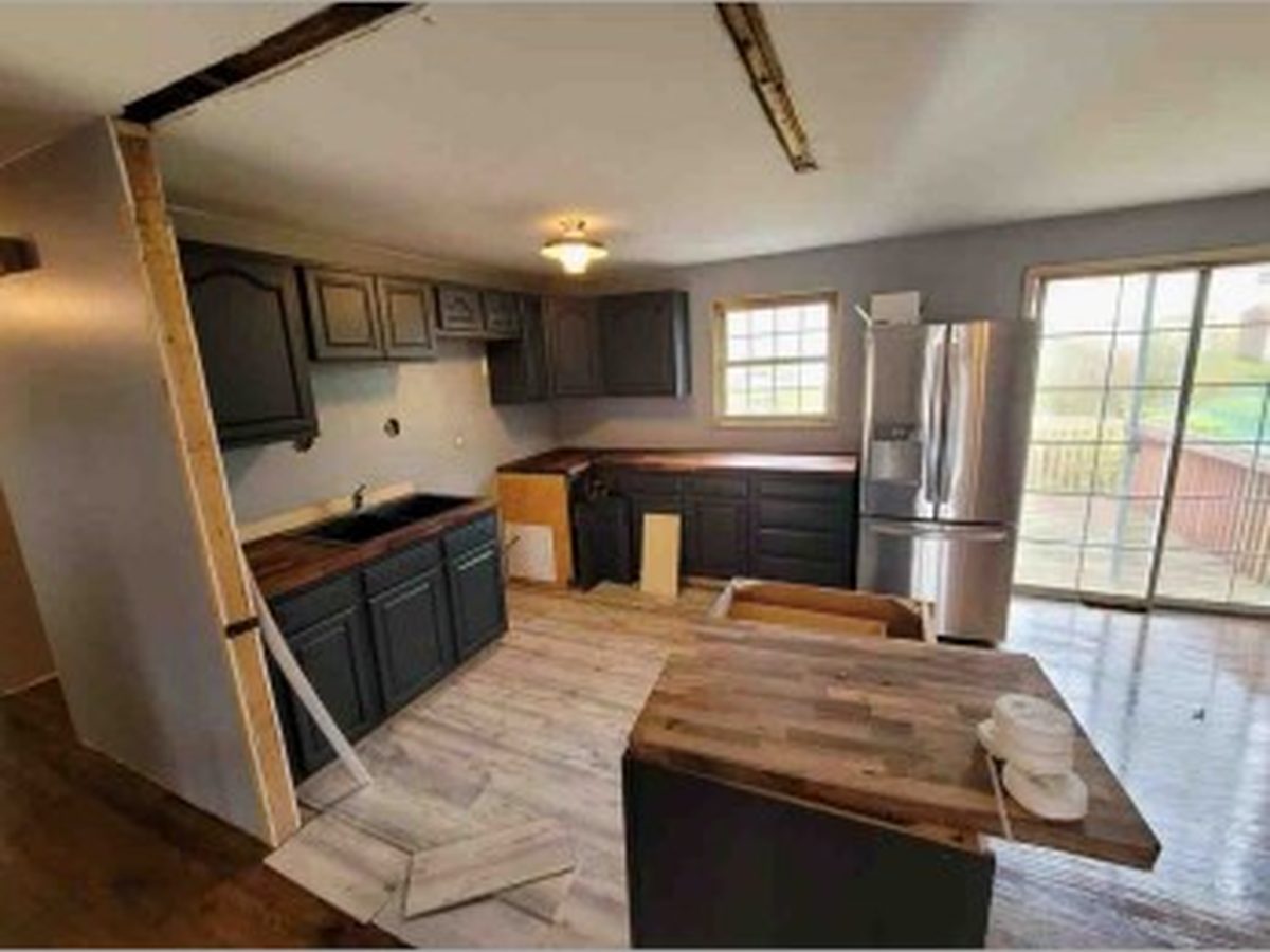 Dated kitchen with dark cabinets mid-demolition